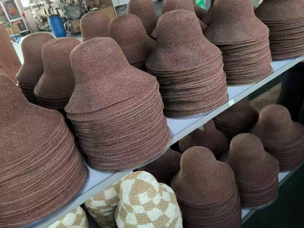 Stacks of woven straw hat bodies waiting to be shaped