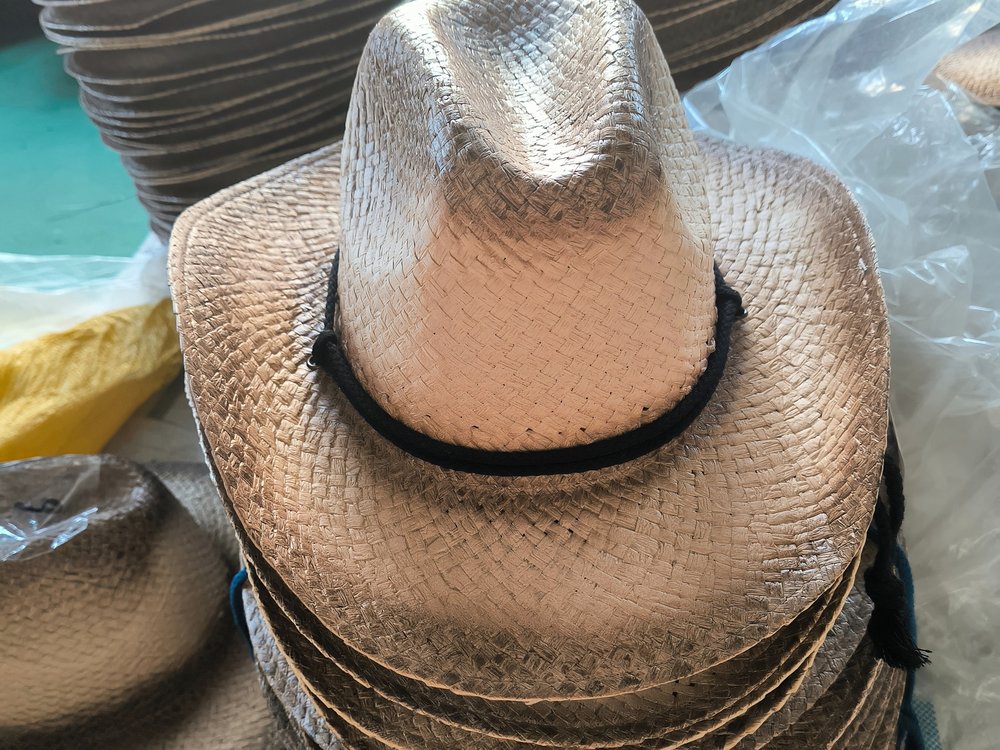 Blocked cowboy hats stacked and batched by size in the workshop